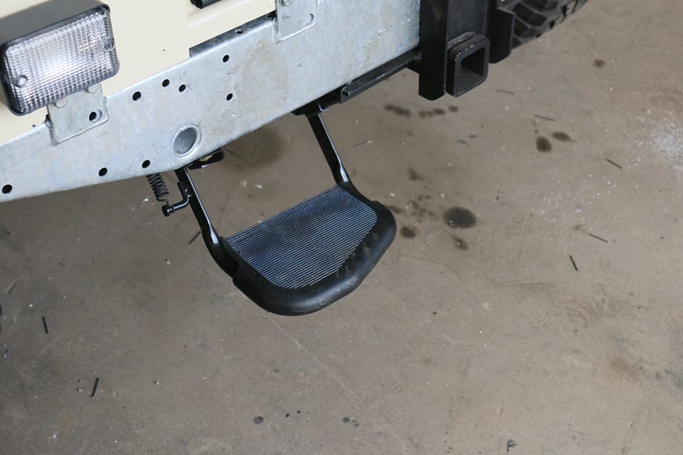 A folding rear step and receiver hitch are installed.